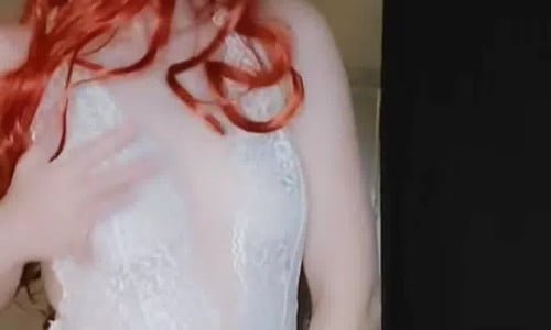 Tori pole dancing with a long red wig on